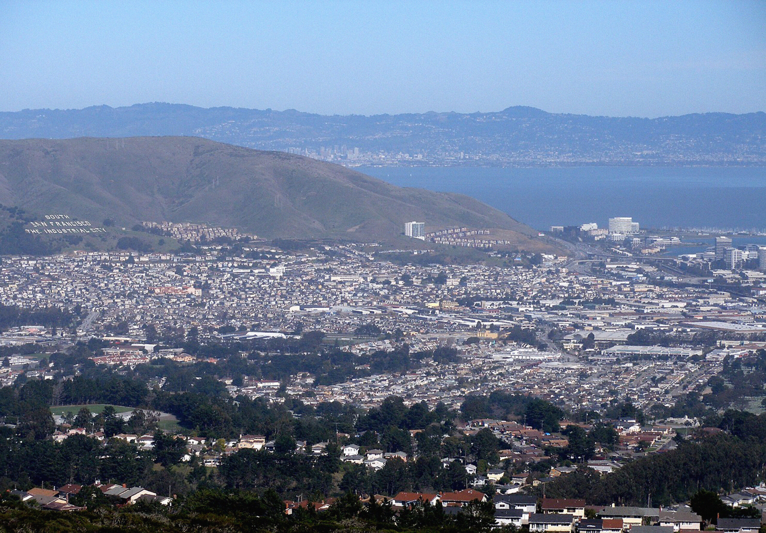 Aerial view of Sign Hill, houses, and the bay in South San Francisco.