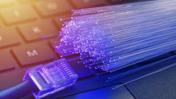 Ethernet cable and fiberoptic cables on top of a closeup of a laptop keyboard